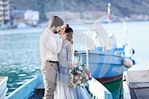 Bride and groom wedding on pier with boats on the sea