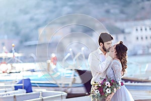 Bride and groom wedding on pier with boats on the sea