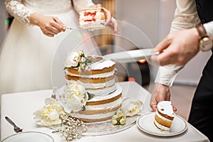 Bride and groom at wedding reception cutting the wedding cake with flowers