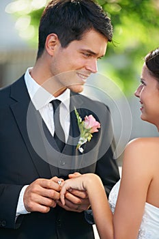 Bride, groom and wedding ring exchange outdoor with love, care and excited for commitment, union or trust. Smile, happy