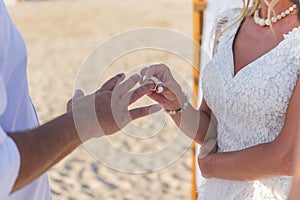 Bride and groom. wedding ring and wedding bouquet. spring summer celebration. he puts a ring on her hand.