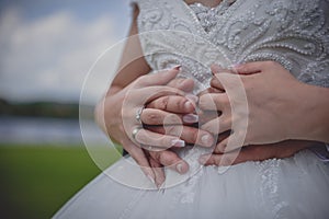 Bride and groom with wedding rings, close up. Young married couple holding hands on their wedding day.