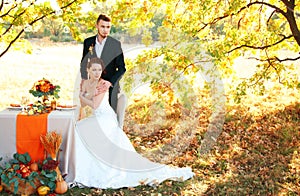 Bride and groom at the wedding table. Autumn outdoor setting.