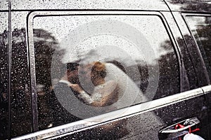bride and groom through window of car