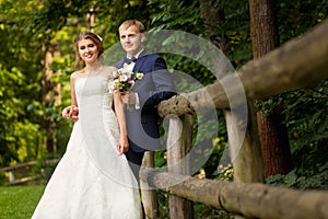 Bride and groom in wood near fence