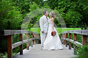 Bride and groom on a wooden bridge