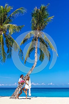 bride and groom, young loving couple, on their wedding day, outdoor beach wedding on tropical beach and sea background