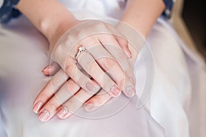 Bride hand with manicure on wedding dress