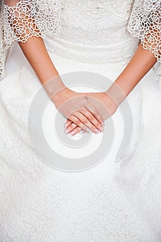 Bride hand on wedding dress with a nice manicure