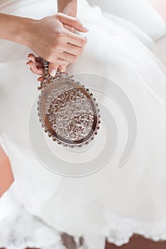 Bride hands on her wedding dress.