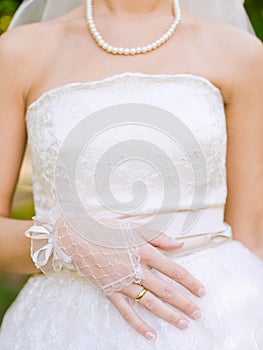 Bride hands with ring over the wedding dress