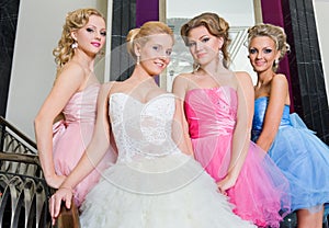 The bride with her bridesmaids on the stairs photo