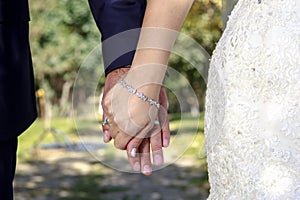 A bride and her groom hold hand