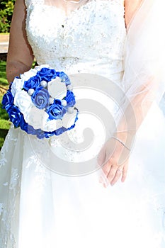 Bride holding blue and white posy of flowers