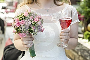 Bride holding bouquet of flowers and a glass of wine closeup wedding marriage