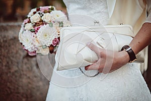 Bride holding bouquet and handbag
