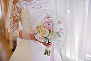 Bride holding delicate marriage bouquet