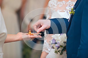 The bride is holding her groom's hand during the ceremony.