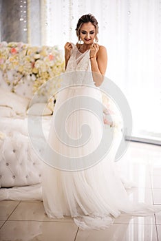 The bride is holding her wedding dress in the boudoir room.