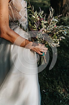 Bride holding rustic wedding bouquet.