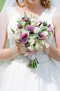 The bride holding soft wedding bouquet of roses, nice wedding bouquet in bride`s hand