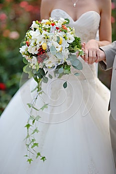 Bride holding wedding bouquet of colorful flowers and roses