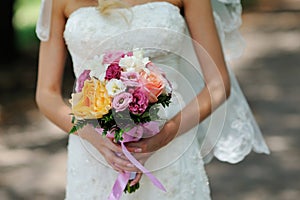 Bride Holding Wedding Bouquet with Orange white and Pink Flowers