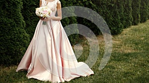 Bride holding wedding bouquet of pink and white flowers in hands