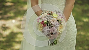Bride is holding a wedding bouquet of roses. Bridal bouquet on wedding day. Bouquet of different flowers.