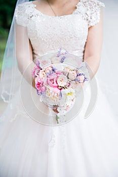 Bride holding wedding bouquet in studio