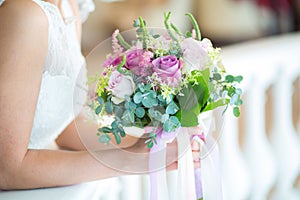 Bride holding wedding bouquet in studio