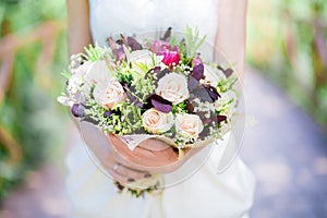 Bride holding wedding bouquet in studio