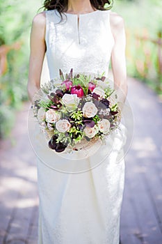Bride holding wedding bouquet in studio