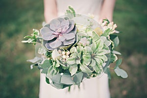 Bride holding the wedding bouquet, with succulent flowers,