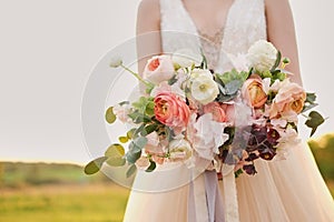 Bride holding a wedding fine-art bouquet in pastel pink colors. closeup.