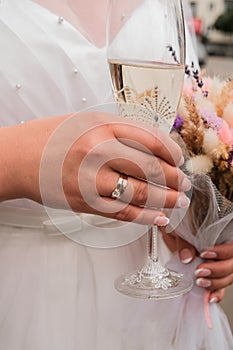 Bride holding wedding glasses with champagne. Celebrating just married. Lovely coule