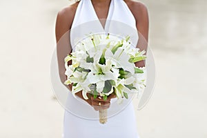 Bride holding white lily flower wedding bouquet