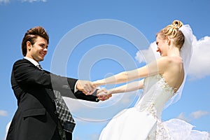 Bride holds fiance for hands