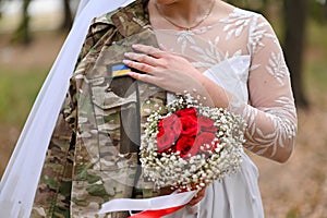 The bride holds the groom& x27;s military jacket. The concept