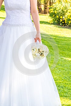 Bride holds in hand a wedding bouquet of flowers in a garden