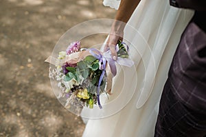 The bride holds her beautiful wedding bouquet with gentle hands