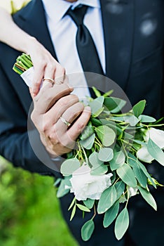 The bride holds her beautiful wedding bouquet with gentle hands