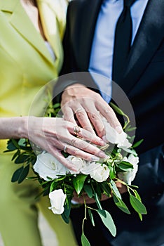 The bride holds her beautiful wedding bouquet with gentle hands