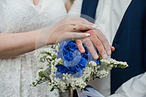 The bride holds her beautiful wedding bouquet with gentle hands