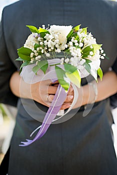 The bride holds her beautiful wedding bouquet with gentle hands