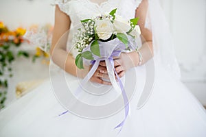 The bride holds her beautiful wedding bouquet with gentle hands