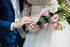 The bride holds her beautiful wedding bouquet with gentle hands