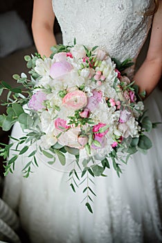 Bride holds rich pink wedding bouquet in her arms