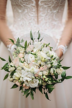 Bride holds a wedding bouquet of flowers