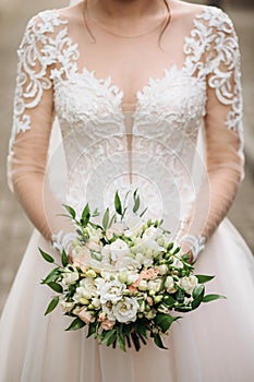 Bride holds a wedding bouquet of flowers